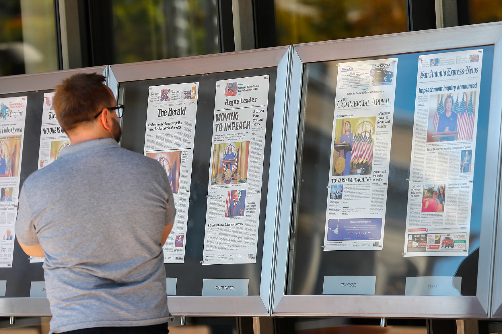 A man stops to look at newspaper front pages